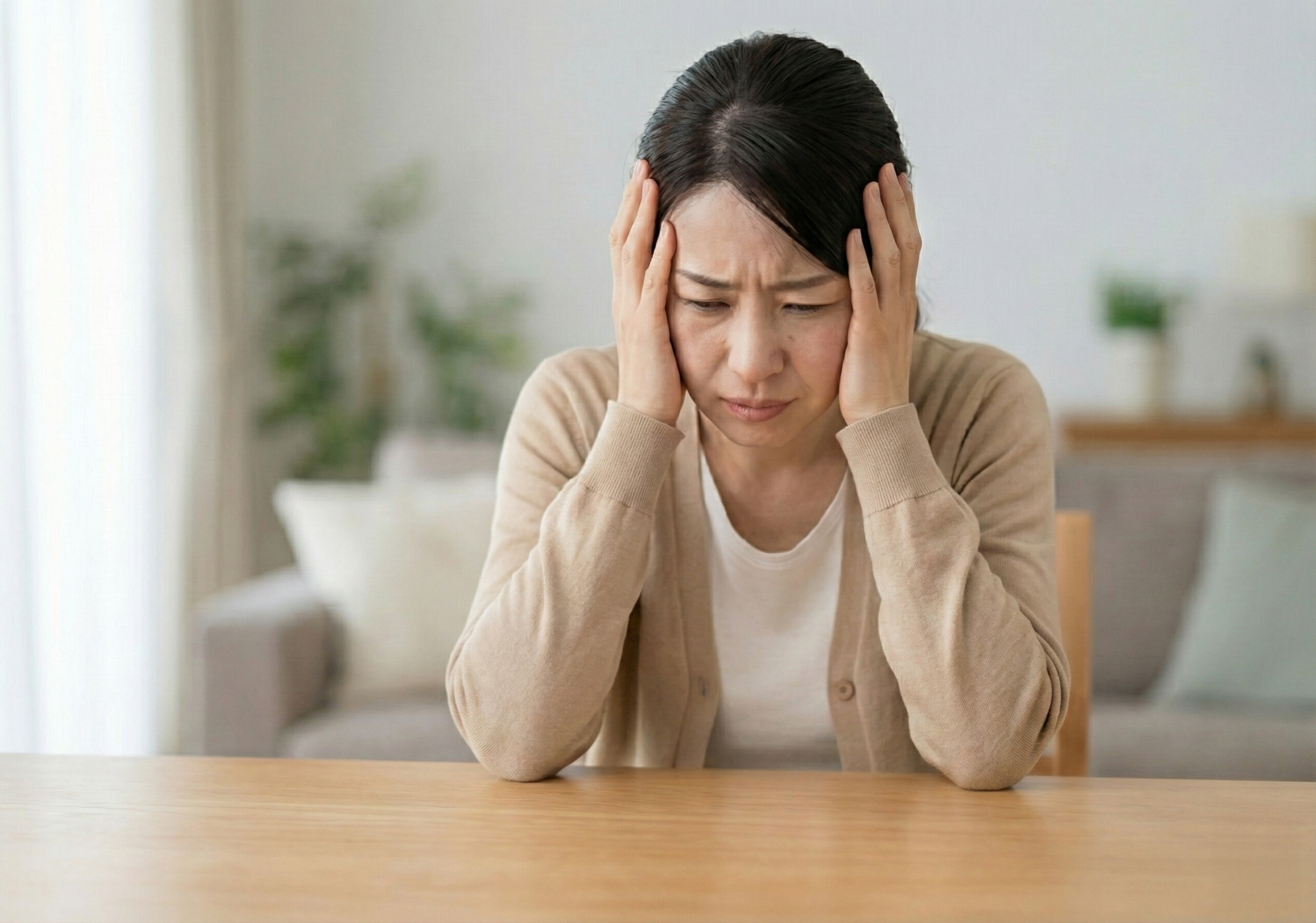 頭を抱えて悩む女性